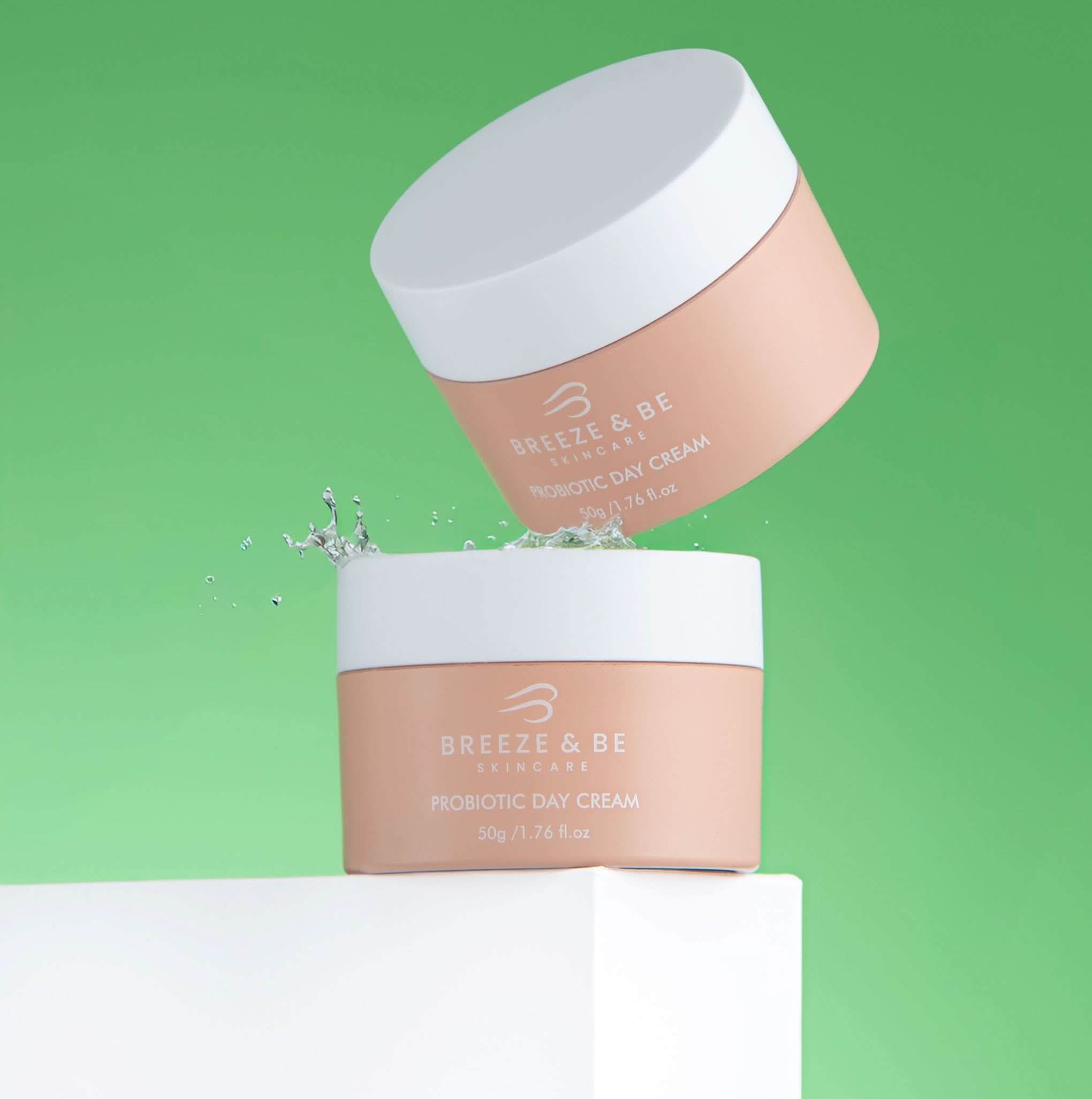 Two jars of Breeze & Be Probiotic Day Cream on a green background