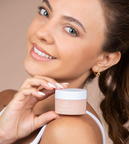 Woman holding a jar of Probiotic cream with a neutral background