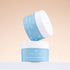 Two containers of Breeze & Be skincare cream on a beige background